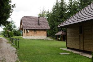 a small building with a fence next to a house at Vile Stefan in Zaovine +44 photos