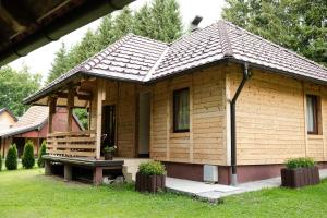 a small wooden house with a bench in the yard at Vile Stefan in Zaovine