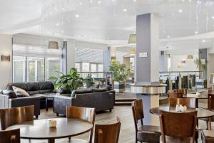 a hotel lobby with tables and couches and chairs at Keepers Cottage - Dartmouth Golf and Spa Resort in Dartmouth
