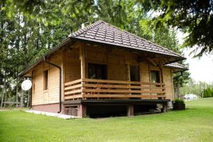 a small wooden house with a porch on the grass at Vile Stefan in Zaovine
