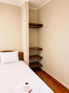 a small room with a bed and a shelf at La Posada Del Pajarito in Yurimaguas +2 photos