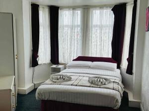 a bedroom with a large bed in front of windows at Ride Side Delton Hotel in Blackpool