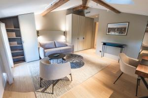 a living room with a couch and a table and chairs at La Villa des Vignes in Saint-Émilion