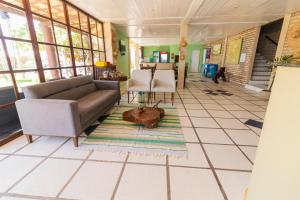 a living room with a couch and a table and chairs at Hotel Platô in Paraipaba