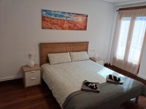 a bedroom with a bed with two shoes on it at Apartamento Gernika in Guernica y Luno