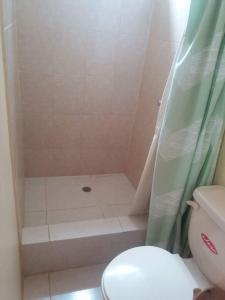 łazienka z prysznicem, toaletą i zasłoną prysznicową w obiekcie Hostal Montecarlos w mieście Salinas