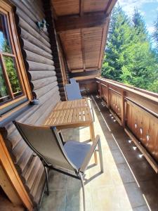 a chair sitting on the porch of a cabin at Enzianhütte Gerlitzen Kanzelhöhe in Kanzelhöhe