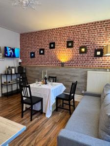 a dining room with a table and a brick wall at Appart 3 pièce hyper centre Strasbourg in Strasbourg