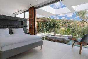 a bedroom with a bed and a large window at A - Luxury Villas in Plomari +90 photos