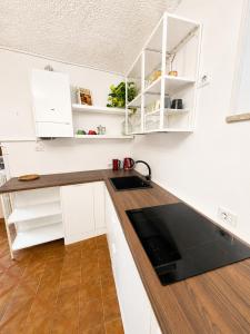 a kitchen with white cabinets and a black counter top at Il Focolare in Subiaco +8 photos