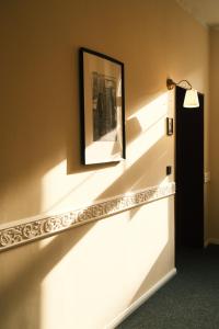 een wandlamp met een schilderij aan de muur bij Hotel DEDE in Augsburg