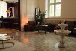 een lobby met een woonkamer met een piano bij Hotel DEDE in Augsburg