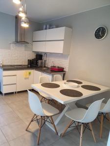 a kitchen with a white table and chairs at Domki w BOSZKOWIE in Boszkowo +39 photos