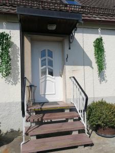 a porch with a white door and a wooden stairs at Thomas Haus 1 in Günzburg