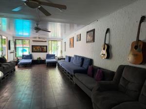 a living room with couches and guitars on the wall at Hostal Loco Coco Loco in Panama City