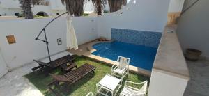 an overhead view of a swimming pool with chairs at Maison du prince in Yasmine