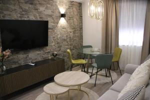 a living room with a table and chairs and a tv at Apartamentos turísticos Desiree in Arévalo