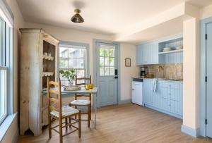 a kitchen with blue cabinets and a table and chairs at The Lightkeeper’s Inn in Edgartown +20 photos