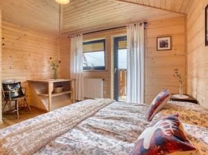 a bedroom with a large bed in a room with wooden walls at Apartamenty Bąkowo Chatka in Witów