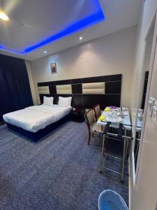 a hotel room with a bed and a table at سحابه صيف للشقق المخدومه - حي الاندلس - in Abha
