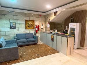 a kitchen with two blue couches and a counter at سحابه صيف للشقق المخدومه - حي الاندلس - in Abha