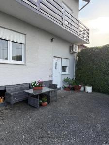a patio with a table and benches in front of a house at Jetlag Bradić in Velika Gorica