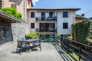 a patio with a table and chairs and a building at Da Mara Lago Di Como in Sormano