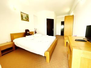a bedroom with a bed with a teddy bear on it at Pensiunea Ursuleț Bran in Bran +46 photos