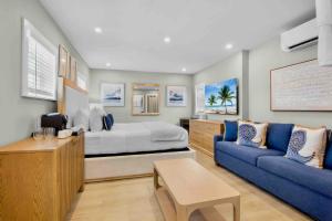 a bedroom with a bed and a blue couch at Haley's at Anna Maria Island Inn in Holmes Beach