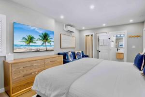 a bedroom with a large bed and a tv on the wall at Haley's at Anna Maria Island Inn in Holmes Beach