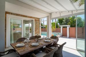 a dining room with a table and chairs at Halkidiki Luxury Villa Palm Oasis Private Pool & Hot Tub in Nea Irakleia