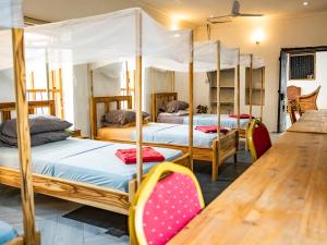 a room with four bunk beds and a wooden table at Old Stone Boutique Lodge in Bagamoyo +180 photos