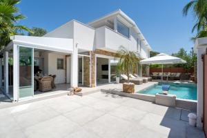 a villa with a swimming pool and a house at Halkidiki Luxury Villa Palm Oasis Private Pool & Hot Tub in Nea Irakleia
