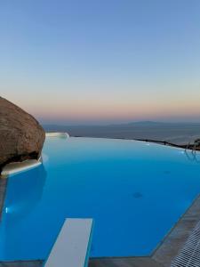 a blue swimming pool with a view of the ocean at Orama suite I in Mikonos