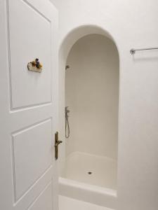 a bathroom with a white door and a bath tub at Orama suite I in Mikonos +5 photos