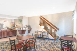 a hotel room with tables and chairs and a kitchen at Super 8 by Wyndham Webster/Rochester in Webster