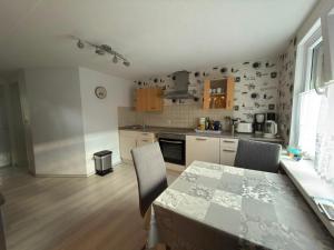 a kitchen with a table and some chairs and a table and a table at klimatisiertes, gemütliches Ferienhaus in Koblenz