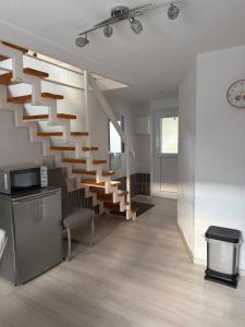 a living room with a staircase in a house at klimatisiertes, gemütliches Ferienhaus in Koblenz +3 photos