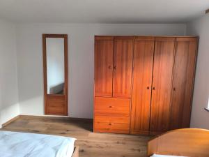 a bedroom with a wooden cabinet and a mirror at Apartment Maria Domžale in Domžale
