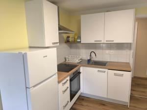 a kitchen with white cabinets and a white refrigerator at Apartment Maria Domžale in Domžale