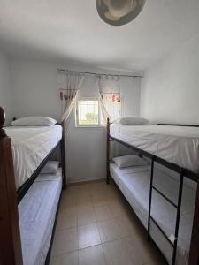 two bunk beds in a room with a window at Mar y piscina in Cabo Negro