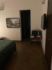 a room with a bed and a television and a door at Executive Guest Room - Helcion Residency in Lahore