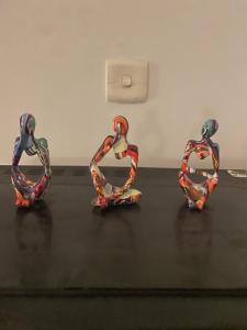three pieces of sculpture sitting on a table at Executive Guest Room - Helcion Residency in Lahore