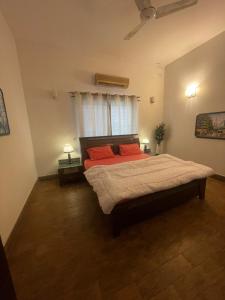 a bedroom with a bed with red pillows and a window at Executive Guest Room - Helcion Residency in Lahore