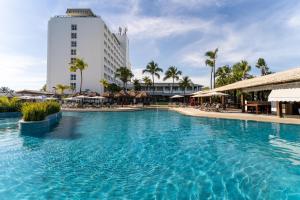 a large swimming pool in front of a hotel at Hotel Deville Prime Salvador in Salvador