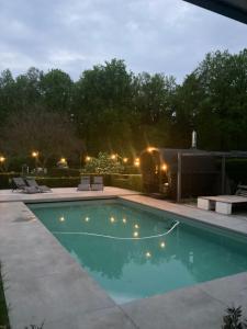 a swimming pool in a backyard at night at logies 2460 in Kasterlee