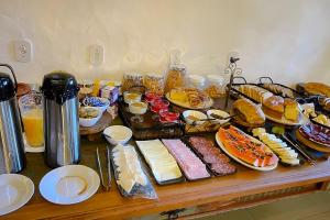 a table topped with plates of food and desserts at VELINN Pousada Canto da Cascata in Camanducaia