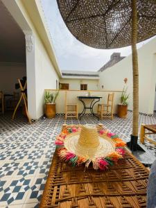 a room with a table and a straw hat on the floor at Riad Le Sultan Rouge And Spa in Marrakesh