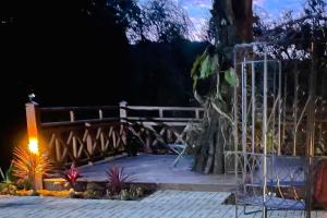a patio at night with a fence and plants at VELINN Pousada Canto da Cascata in Camanducaia
