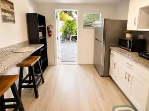 a kitchen with a stainless steel refrigerator and a counter at Quiet & Centrally located House - PRIVATE PARKING, LAUNDRY AND STORAGE FOR LUGGAGE in Miami